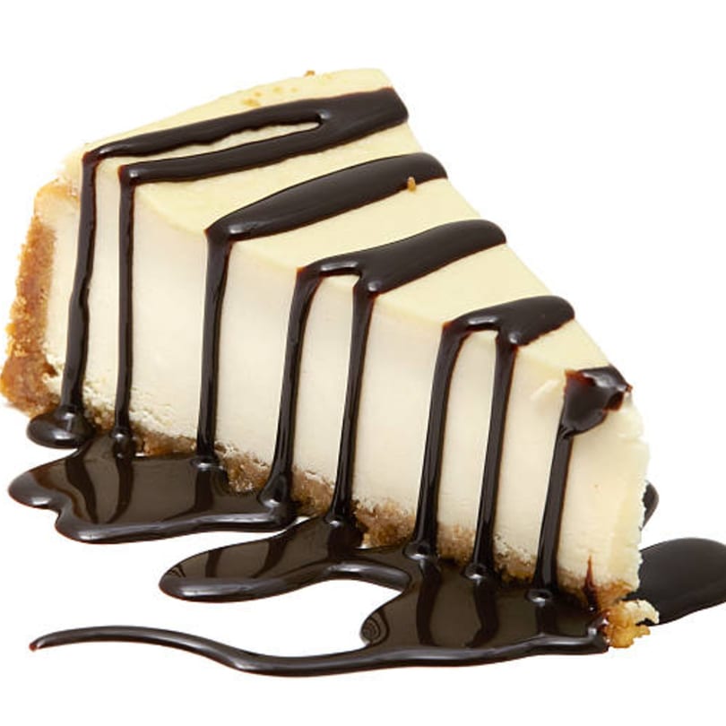 A slice of cheesecake with a graham cracker crust, drizzled with chocolate syrup.