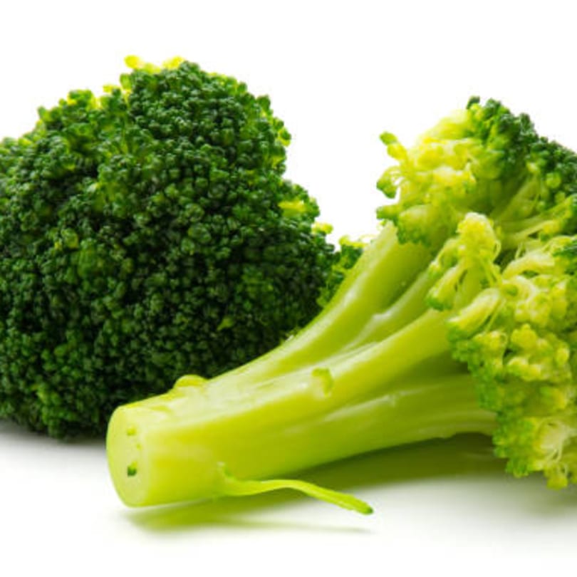 Fresh green broccoli florets and stalks, ready for an Italian dish, against a white background.